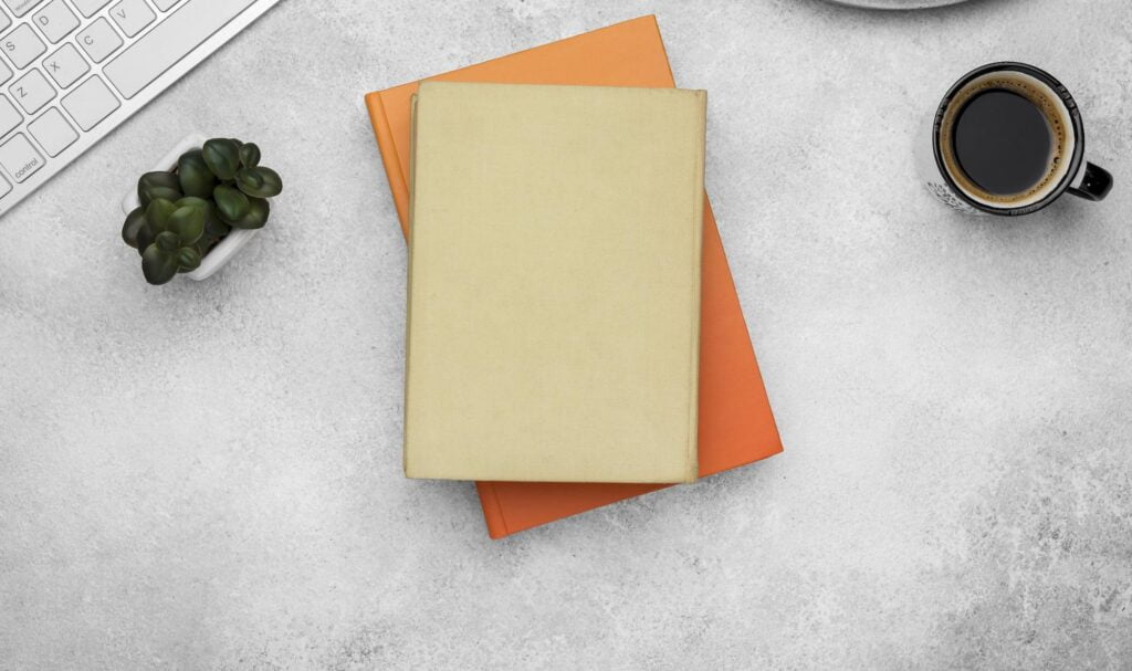 10 Ide Hadiah Natal untuk Teman Kantor yang Berfaedah - top view hardback books desk with coffee 10 Ide Hadiah Natal untuk Teman Kantor yang Berfaedah - top view hardback books desk with coffee