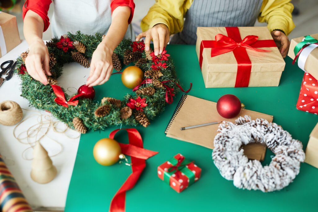 25+ Ide Hadiah Natal untuk Teman Kerja - happy couple preparing christmas gifts wreath Ide Hiasan Natal Buatan Sendiri