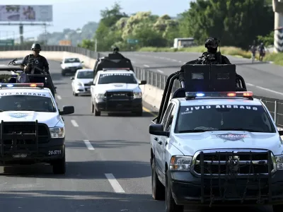 Anggota Garda Sipil mengawal truk pengangkut lemon (di luar rangka) di ruas jalan raya Apatzingan-Nueva Italia, Negara Bagian Michoacan, Meksiko, pada 20 September 2023. - Hak Cipta ALFREDO ESTRELLA/AFP atau pemberi lisensi